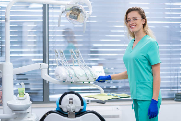 Cheerful female dentist , smiling and looking at camera while working in modern office of dental clinic