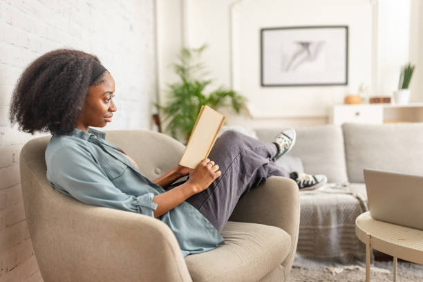 istock Casually dressed person engrossed in book in cozy home. 2166591075