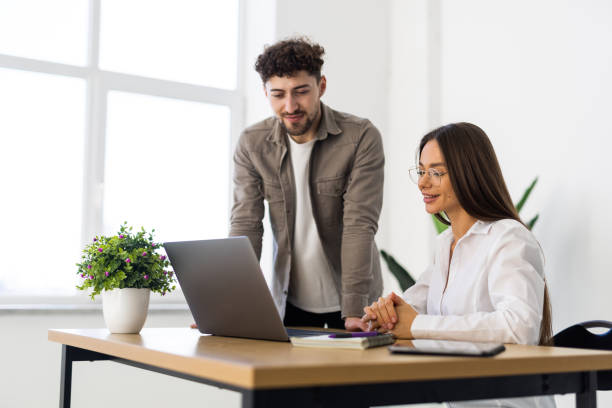 istock Young businesswoman reading document with colleague in office 2166592576