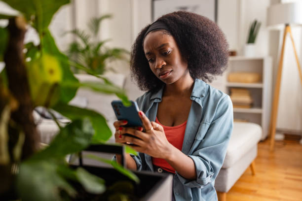 istock Individual using smartphone beside a green plant inside. 2166593633