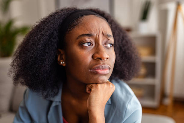 istock Pensive woman looking out window with hand on chin 2166594047