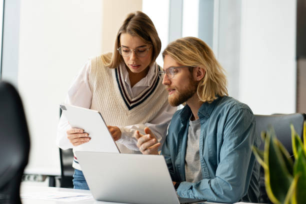 istock Two business colleagues having meeting discussing using digital tablet and laptop at the office 2166594131
