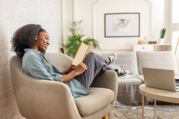 istock Person reading book in a cozy living room setting 2166595562