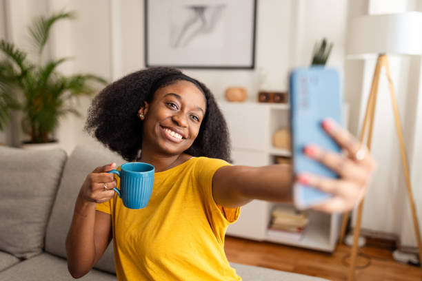 istock Smiling woman taking a selfie holding a blue mug 2166597315