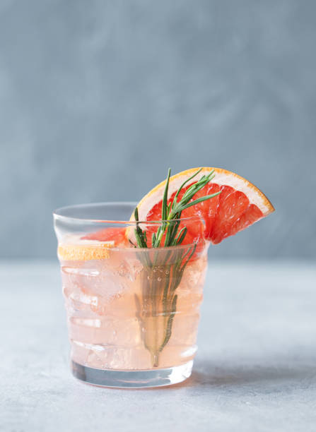 istock Grapefruit lemonade drink in a glass with rosemary and ice on a blue background. 2166597718