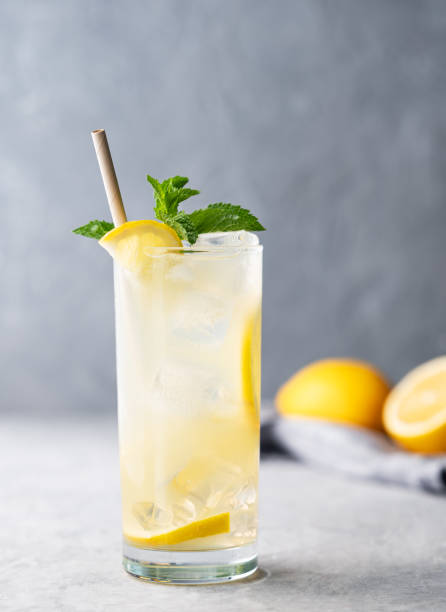 istock Freshness mojito drink with lemon, mint and ice. Citrus lemonade on a light background with napkin and fruits. 2166598448