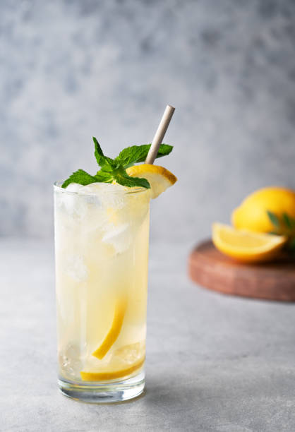 istock Freshness mojito drink with lemon, mint and ice. Citrus lemonade on a blue background with wooden board and fruits. 2166598641