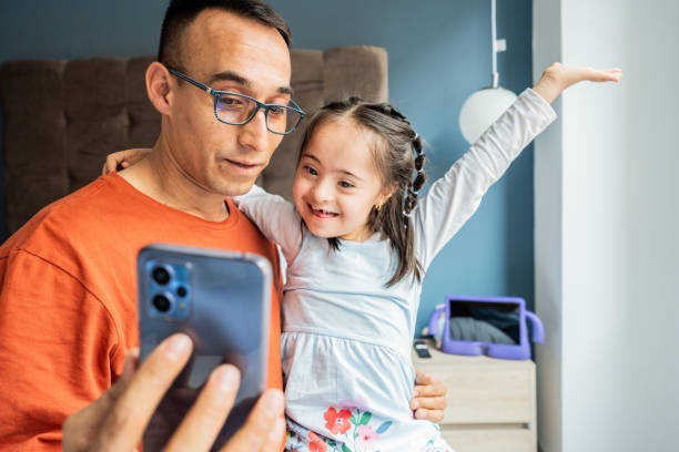istock Daughter and father on a video call using mobile phone at home 2166600210