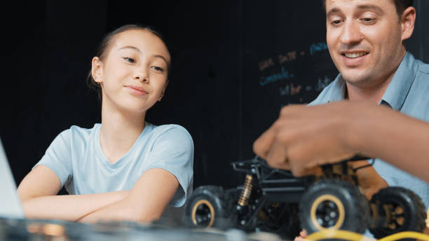 istock Caucasian girl looking at car model at blackboard with prompt. Edification. 2166600645
