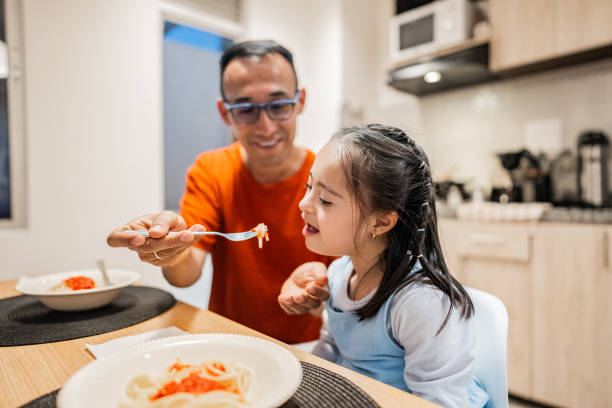 istock Father and daughter eating together at home 2166600906