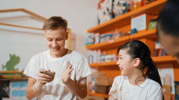 istock Smart teenager modeling cup of clay while laughing at art lesson. Edification. 2166601379