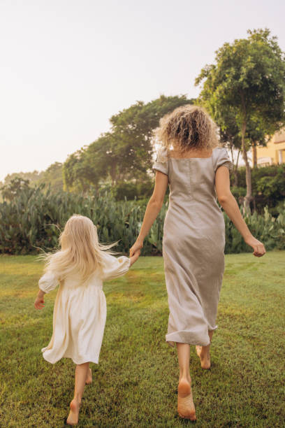 istock Mother and daughter dancing in the meadow 2166602719