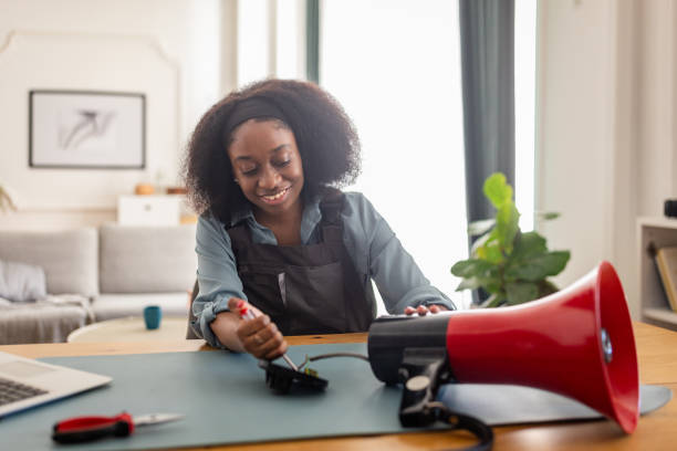 istock Woman repairing a device, using a screwdriver, smiling. 2166604565