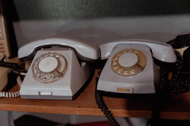 istock Two vintage rotary telephones sit side by side on a shelf 2166604641