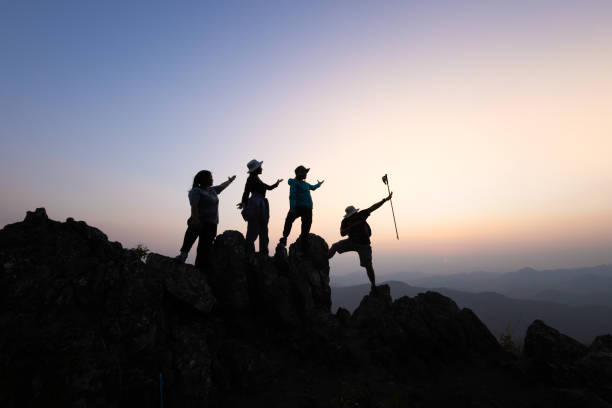 istock Silhouette of a group of climbers on a mountaintop. Success, teamwork and unity. 2166605541