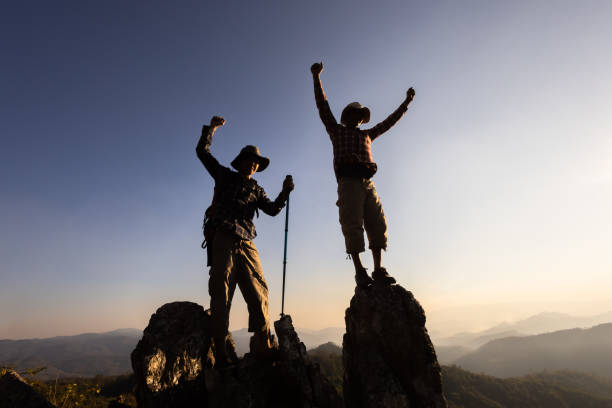 istock Silhouette of a group of climbers on a mountaintop. Success, teamwork and unity. 2166605542
