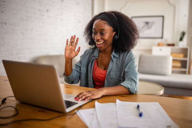 istock Woman waves during video chat in home office 2166608784