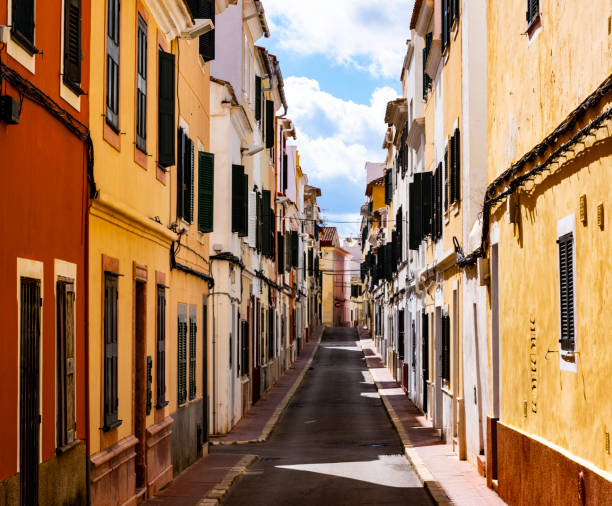 Narrow Ancient Street in Sunny Day on Blue Sky background Outdoors. Mahon, Menorca, Spain