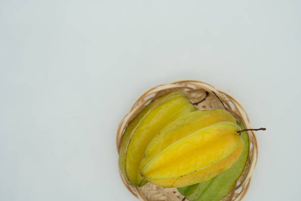The carambola is a popular tropical fruit with a distinctive five-pointed star shape. It is sweet and sour and juicy and is often eaten directly or made into juice and salads. The white background highlights the bright color and unique shape of the fruit.