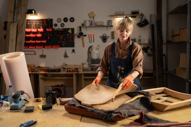 Timeless Restoration: Elderly Woman Expertly Disassembling Vintage Armchair in Workshop