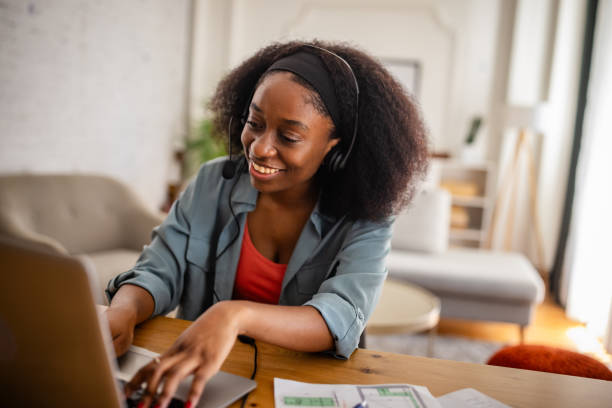 istock Woman working at a laptop with a headset on 2166610442