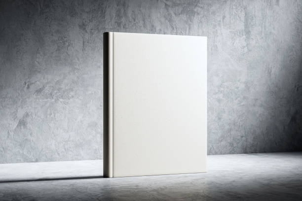 Hardcover book mockup standing on a concrete floor with a grey textured wall background. 3D Rendering