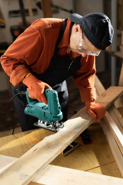 Skilled Female Carpenter Using Jigsaw in Workshop for Woodworking Project