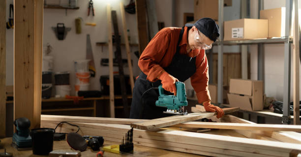 istock Woman carpenter using jigsaw machine on wooden plank workshop 2166610732