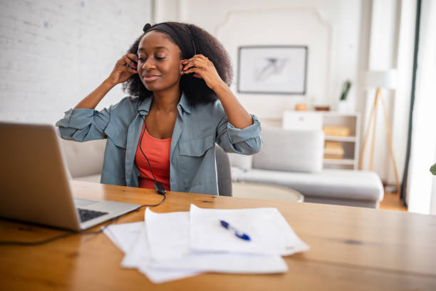 istock Young woman testing headphones in home office. 2166611340