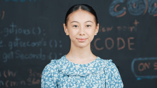 istock Cute caucasian girl looking at camera while standing at blackboard. Edification. 2166613078