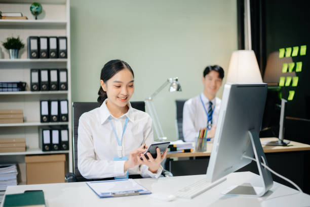 istock Two young Asian professionals engaged in teamwork and business discussions in modern office embodying corporate 2166614190