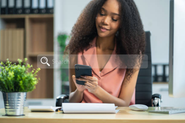 istock Female hand working search page on computer and writing on a notepad with a pen in the office. on the wooden desk there a graph business diagram. 2166614468