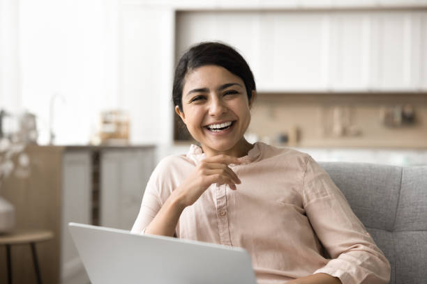 istock Woman sit on sofa with laptop laughing look at camera 2166614855