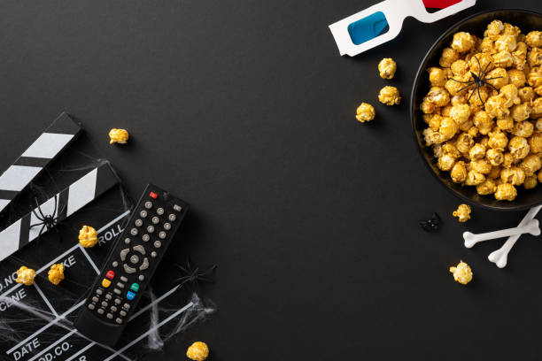 istock Halloween theme setup featuring a bowl of popcorn, remote control, 3D glasses, clapperboard, and spider decorations 2166615904