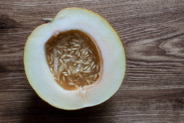 Half ripe melon on wooden table top view still life