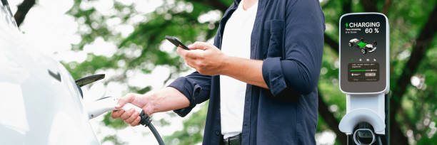 istock Man using smartphone to pay for electric car charging. Exalt 2166617517