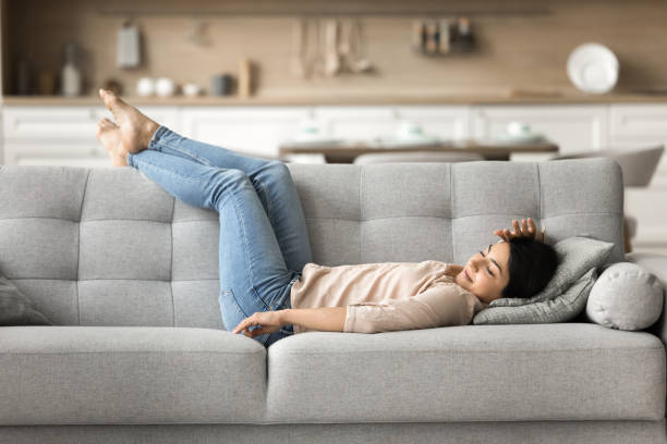 istock Serene Indian woman enjoy daytime nap lying on comfy sofa 2166620376