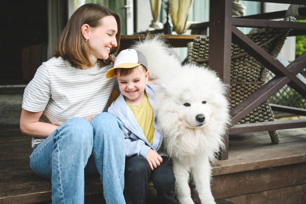 istock mother and little son play with a dog 2166621570