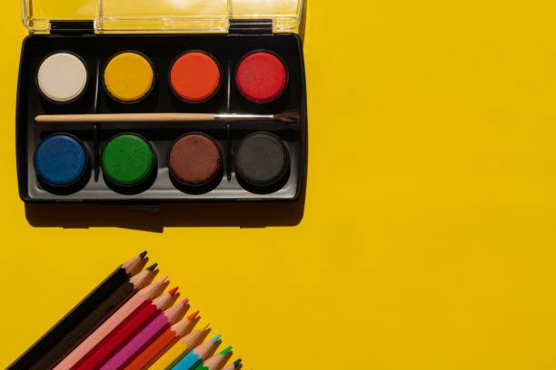 Colored pencils and watercolor paint on the yellow background