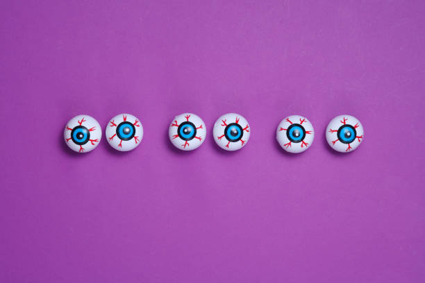 Eyeballs on a purple background. Minimalistic Halloween still life