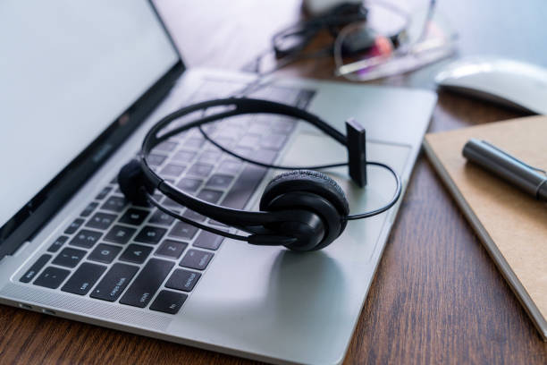 istock Headset, hotline support concept in office. VOIP headset on desk with laptop computer. 2166625419