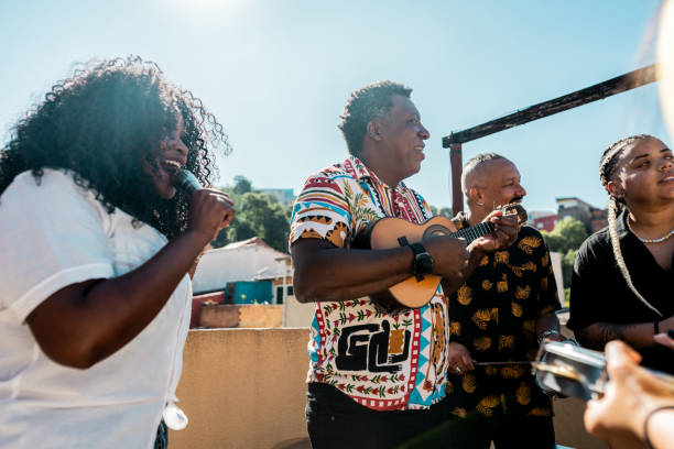 Friends singing and playing musical instruments during party on rooftop