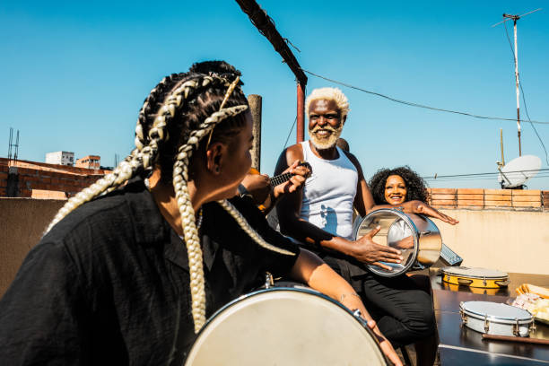 Friends singing and playing musical instruments during party on rooftop