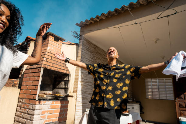 istock Mature man having fun with friends on barbecue at rooftop 2166629258