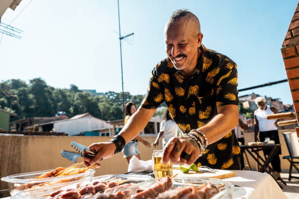 istock Mature man doing barbecue with friends on rooftop 2166629264