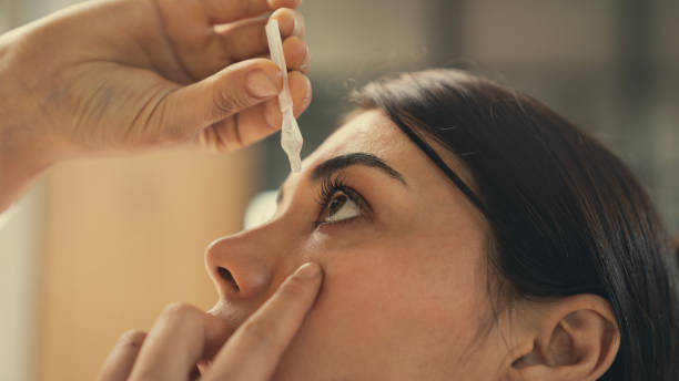 istock Young woman putting eye drops at home 2166631496