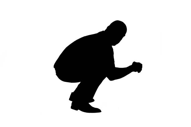 silhouette of a side view of a man looking at camera and sitting squatting on white background