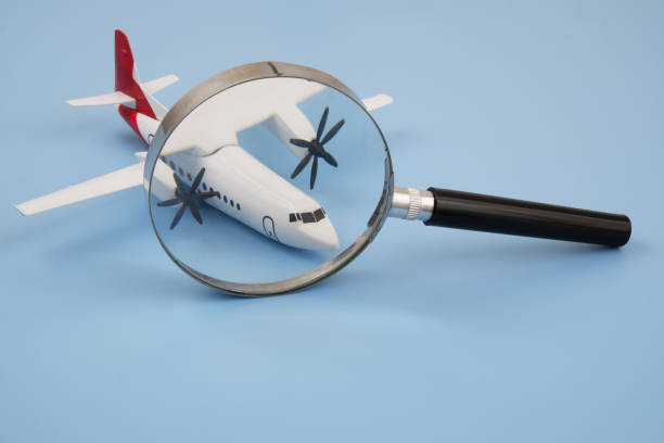 istock Airplane under magnifying glass on blue background. 2166632613
