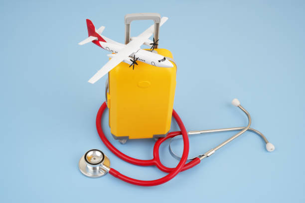 istock Airplane on suitcase and stethoscope on blue background. 2166632630