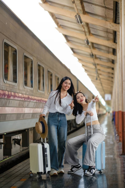istock Two women are standing next to each other with suitcases 2166633181